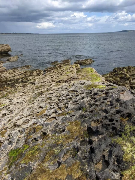 Deniz ve gökyüzü ile kayalık sahil manzarası
