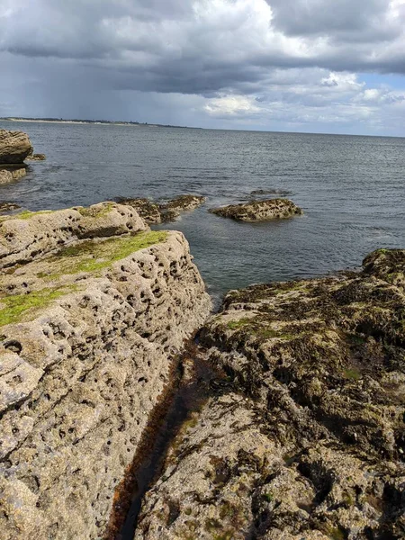 Deniz ve gökyüzü ile kayalık sahil manzarası