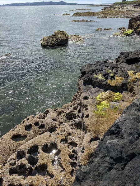 Deniz ve gökyüzü ile kayalık sahil manzarası