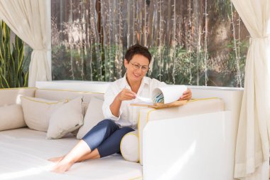 İşçiler dizüstü bilgisayarla kanepeye oturur ve gülümserler.