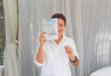 Beyaz perdelere karşı dizüstü bilgisayarı olan kadın.