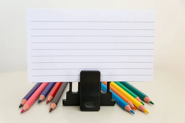 Schoolaccessoires op een witte tafel, vel papier en potloden — Stockfoto