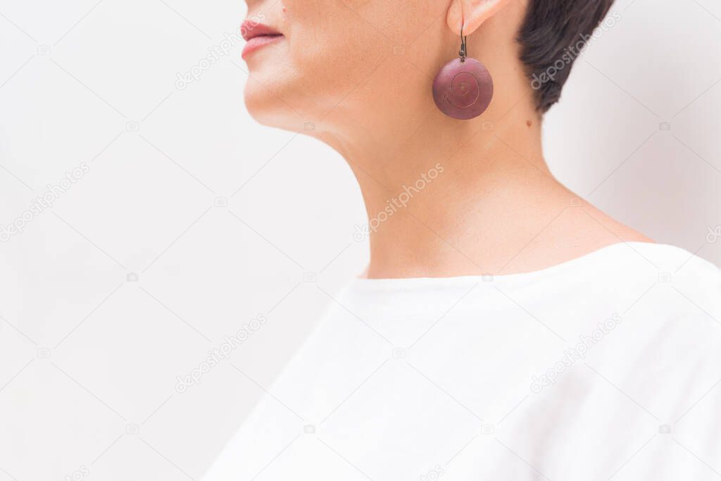 hearing, health, beauty and piercing concept - close up of womans ear, earing