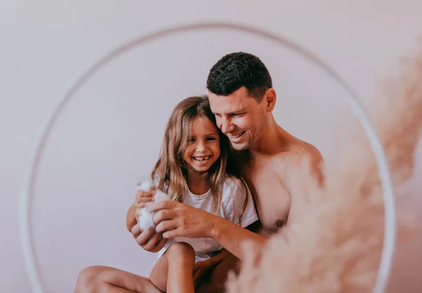 Happy affectionate loving single father and cute small child daughter bonding embracing laughing sit on sofa. — Stock Photo, Image