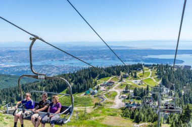Vancouver, British Columbia / Canada - 06 / 15 / 2015 Grouse Mountain sandalye kaldırma, yel değirmeni ve ahşap oymalar buradaki manzaralardan bazıları