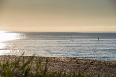 Öğleden sonra Mandurah 'ta sakin bir denizde tek başına kürek çeken bir pansiyoner.