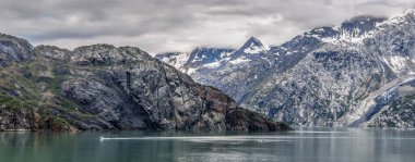 Alaska Buzul Körfezi 'nde bulutlu gökyüzü olan dağlar ve okyanuslar