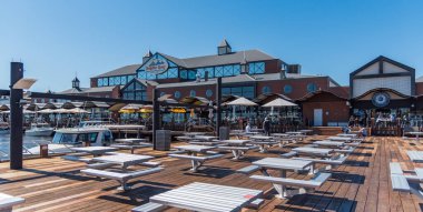 Mandurah, WA / Avustralya - 08 / 26 / 2018 Dolphin Quay Marina ve Mandurah 'taki mağazaları ve restoranları olan tahta kaldırım