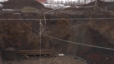 Kazılmış bir siperde çok kirli bir inşaat alanında aletler var.