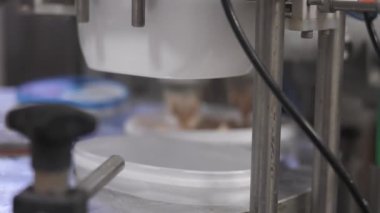 Süt, konveyör beyaz plastik kutuları çikolatalı dondurmayla dolduruyor.