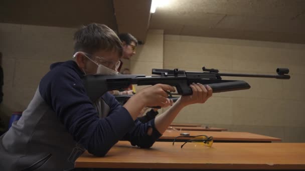 Das Kind Schießt Aus Einem Schwarzen Luftgewehr Mit Fragmentierungsbrille Und — Stockvideo