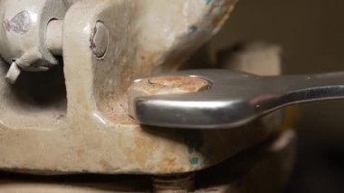 Metal anahtar kullanan bir adam vidayı söker.