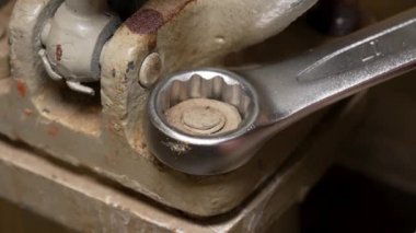 Metal anahtar ve eldivensiz eller kullanan bir adam fındığı söker.