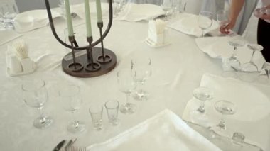Kadınlar okyanustaki büyük bir çadırda, beyaz masa örtüleriyle kaplı büyük masalar servis ediyorlar.