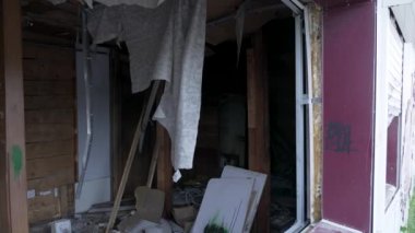 Terk edilmiş ahşap bir evin içinde bir sürü çöp var.
