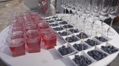 Açık büfe doğada ama beyaz masa örtüsü ile yuvarlak masa. Meyve, meyve suyu ve şampanya bardakları