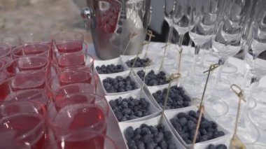 Açık büfe doğada ama beyaz masa örtüsü ile yuvarlak masa. Meyve, meyve suyu ve şampanya bardakları