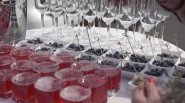 Açık büfe doğada ama beyaz masa örtüsü ile yuvarlak masa. Meyve, meyve suyu ve şampanya bardakları