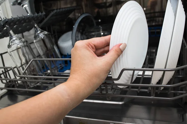 Cleaning the kitchen. Washing dishes in the dishwasher