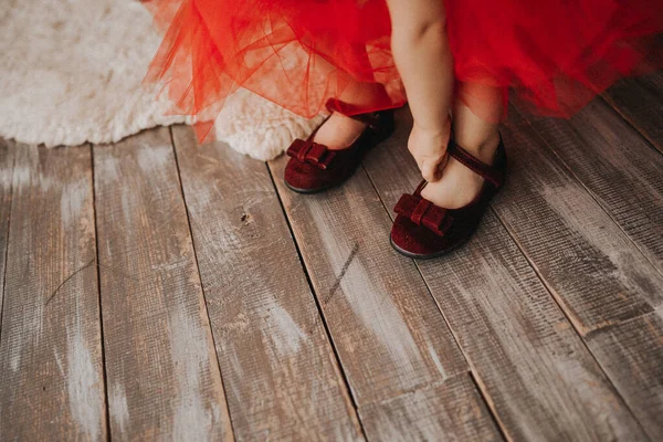 Девушка в красном платье надевает красные туфли — стоковое фото