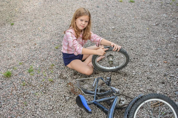 Bir kız çocuğu bisiklet tekerleğine zarar verdi ve işlemden geçmeden fotoğraf onarıyor.