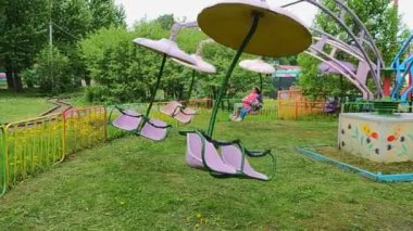 Çocuklar lunaparkta atlı karıncaya binerler.
