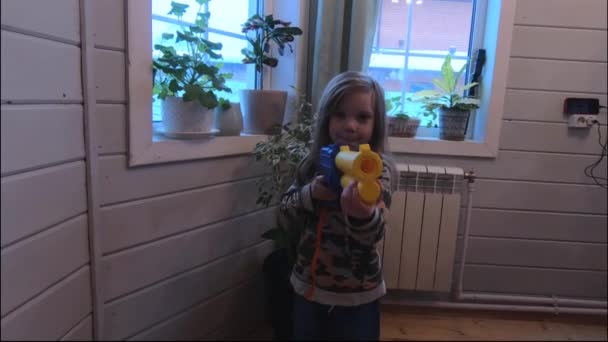 Κορίτσι Παιδί Στο Σπίτι Πυροβολεί Μαλακά Μπαλάκια Από Ένα Αεροβόλο — Αρχείο Βίντεο