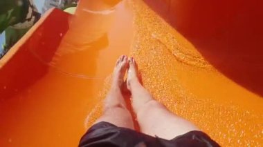 men feet on the slide in the water park