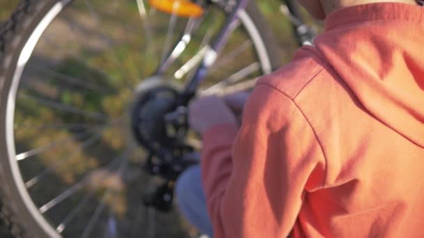 Niño Suéter Naranja Arregla Una Rueda Monta Una Bicicleta Soleado — Vídeo de stock