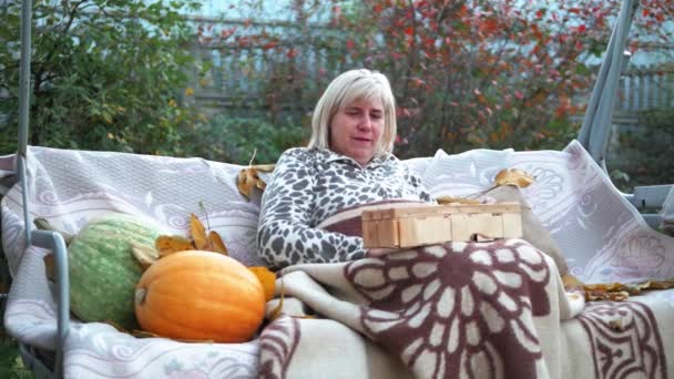 Kobieta Sortuje Owoce Uprawiane Ogrodzie Siedząc Huśtawce Jesienną Pogodę Pokryta — Wideo stockowe