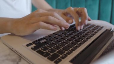 Kadın kafede uzaktan çalışıyor. Laptop klavyesinde kadın tipler. Çatı katı iç mimarisi ile ortak çalışma merkezi. Serbest iş yeri.