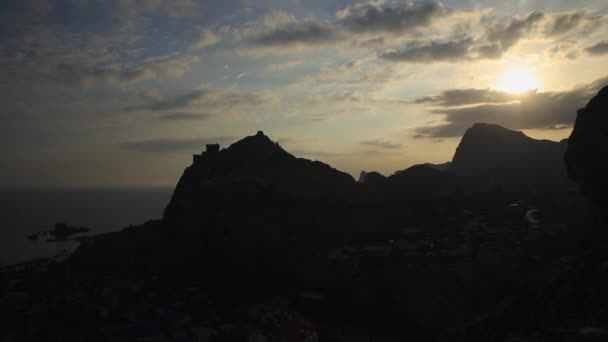 Panorama of ancient Genoese fortress in Sudak town. Silhouette of historic architectural landmark at sunset. Crimea. — Stock Video