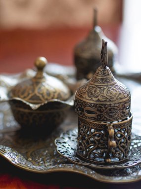 Metal vazolar ve tabutlar. Oryantal şekilli bulaşıklar. Çay partileri için oymalı sofra takımı.