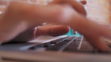 Kadın, kırmızı tuğlalı duvarları olan bir kafede çalışıyor. Laptop klavyesinde kadın tipler. Çatı katı iç mimarisi ile ortak çalışma merkezi. Serbest iş yeri.