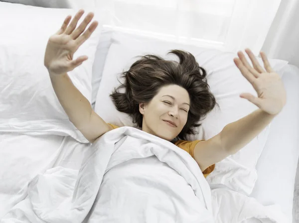 여자는 침대에 스트레칭한다 수있다 천으로 아마포 위에서 — 스톡 사진