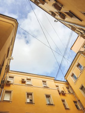 Yakın inşa edilmiş evlerin sarı duvarlarının alt manzarası. Dar avluya da iyi denir. Moskova, Rusya 'daki eski bina..