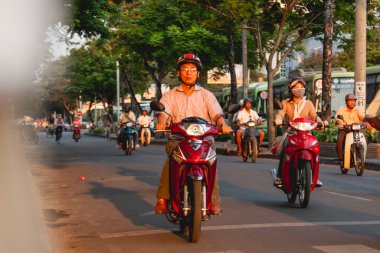 HO CHI MINH, VİETNAM - 28 Mart 2009. Ho Chi Minh şehrinin tarihi merkezinde yerel halk sokakta motosiklet kullanıyor..