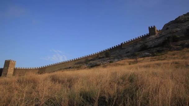 Vista inferior de la antigua fortaleza genovesa en Sudak. Monumento arquitectónico histórico al atardecer. Crimea. — Vídeo de stock