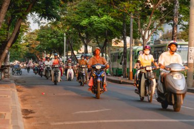 HO CHI MINH, VİETNAM - 28 Mart 2009. Ho Chi Minh şehrinin tarihi merkezinde yerel halk sokakta motosiklet kullanıyor..