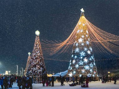 ODINTSOVO, RUSSIA - 3 Ocak 2021. Ampullerle süslenmiş Noel ağaçları. İnsanlar kış tatilinde Vatanseverlerin parkında yürüyor..