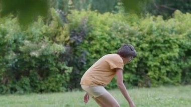 Kadın çimlerde frizbi oynuyor. Yaz titreşimleri. Açık hava eğlence aktivitesi. Aile hayatı. Arka bahçede spor maçı.