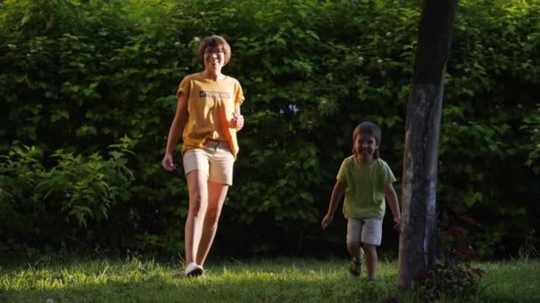 Мати і син грають у фрібі на газоні. Літо вібрує. Відкритий відпочинок. Сімейне життя. Спортивна гра на задньому дворі . — стокове відео