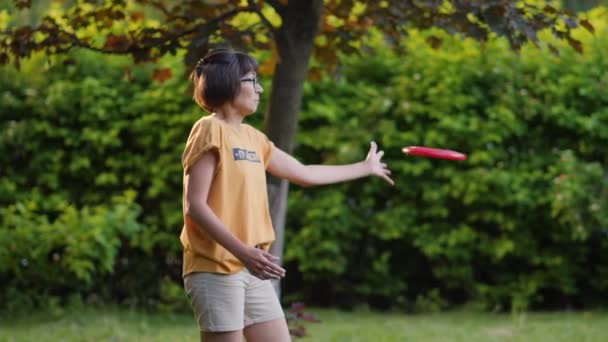 La mujer juega al frisbee en el césped. Vibras de verano. Actividad de ocio al aire libre. Vida familiar. Juego de deportes en el patio trasero. — Vídeo de stock