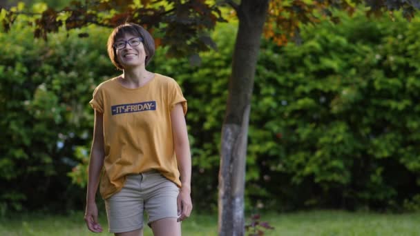 La mujer juega al frisbee en el césped. Vibras de verano. Actividad de ocio al aire libre. Vida familiar. Juego de deportes en el patio trasero. — Vídeo de stock