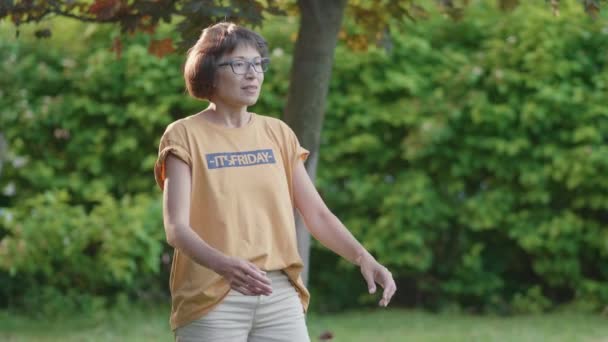 Vrouw speelt frisbee op gras gazon. Zomer vibes. Vrijetijdsbesteding buitenshuis. Het gezinsleven. Sport spel in de achtertuin. — Stockvideo