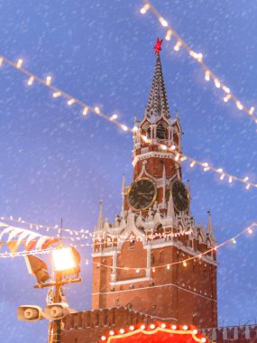 Kremlin 'in Spasskaya Kulesi, ampullerin arkasından bakın. Moskova 'daki Kızıl Meydan' da geleneksel Noel panayırı. Rusya.