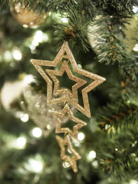 キラキラした装飾が施されたクリスマスツリー 黄金の星と新年のお祝いのためのボールで飾られたモミの木 — ストック写真