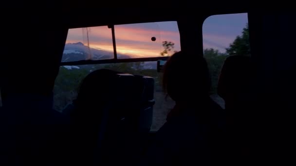 People shoot colorful sunset through windows of moving bus. Journey around Kamchatka peninsula, Russia. — Stockvideo