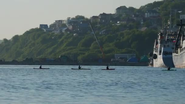 PETROPAVLOVSK-KAMCHATSKY, RUSSIE - 30 juin 2021. Les touristes en kayak passent les bateaux dans le port. — Video