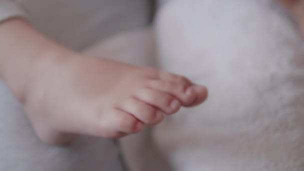 Moeder verbandt haar kinderen met een grote teen en snijdt nagels aan de andere voet. Close-up foto van kinderen voet met verbonden vinger. Eerste hulp in geval van kleine binnenlandse schade. — Stockvideo